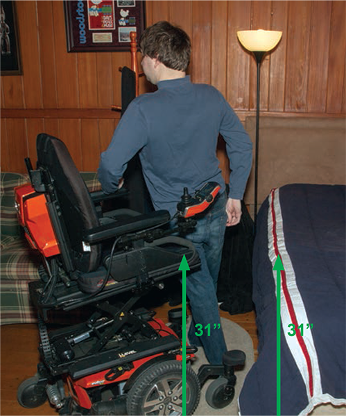 Josh does a stand-pivot transfer independently while holding on to the armrests of the chair.